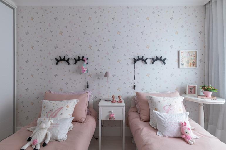 Rafael Renzo - Neste quarto compartilhado por duas irmãs, o rosa pastel protagoniza o delicado desenho do papel de parede, o enxoval das caminhas