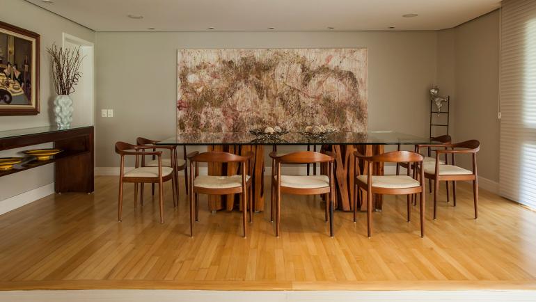 Eduardo Pozella - Na sala de jantar, a cor palha realiza uma composição harmoniosa com o amadeirado presente no piso e no mobiliário