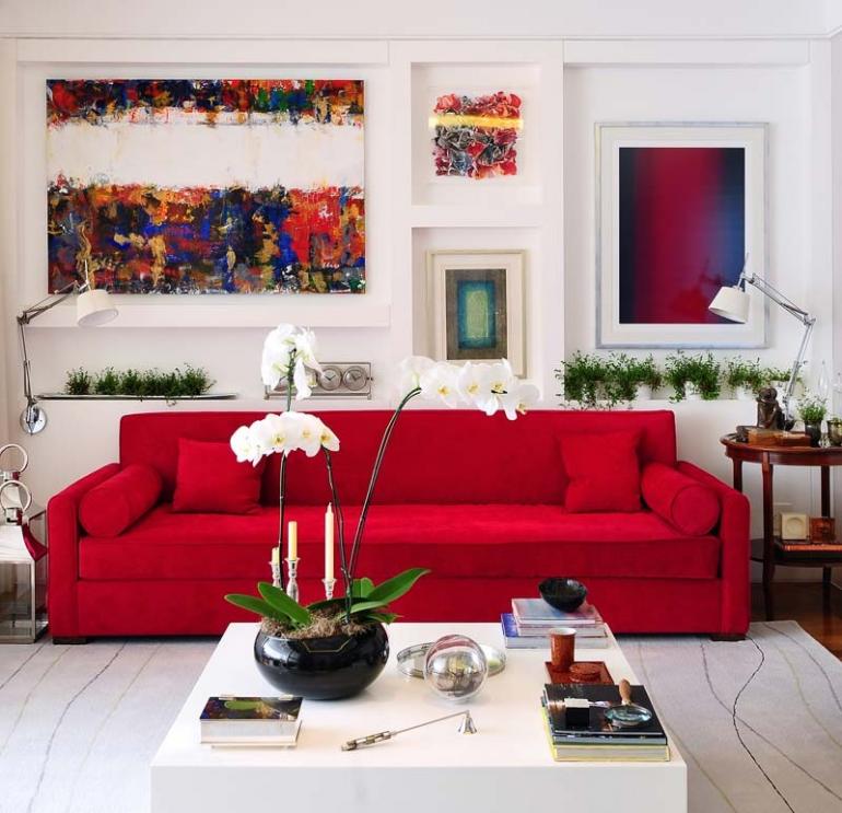 Carlos Piratininga - No contraponto ao sofá vermelho e os quadros coloridos, elementos brancos, como a mesa de centro em laca brilhante, a parede e o cinza claro do tapete
